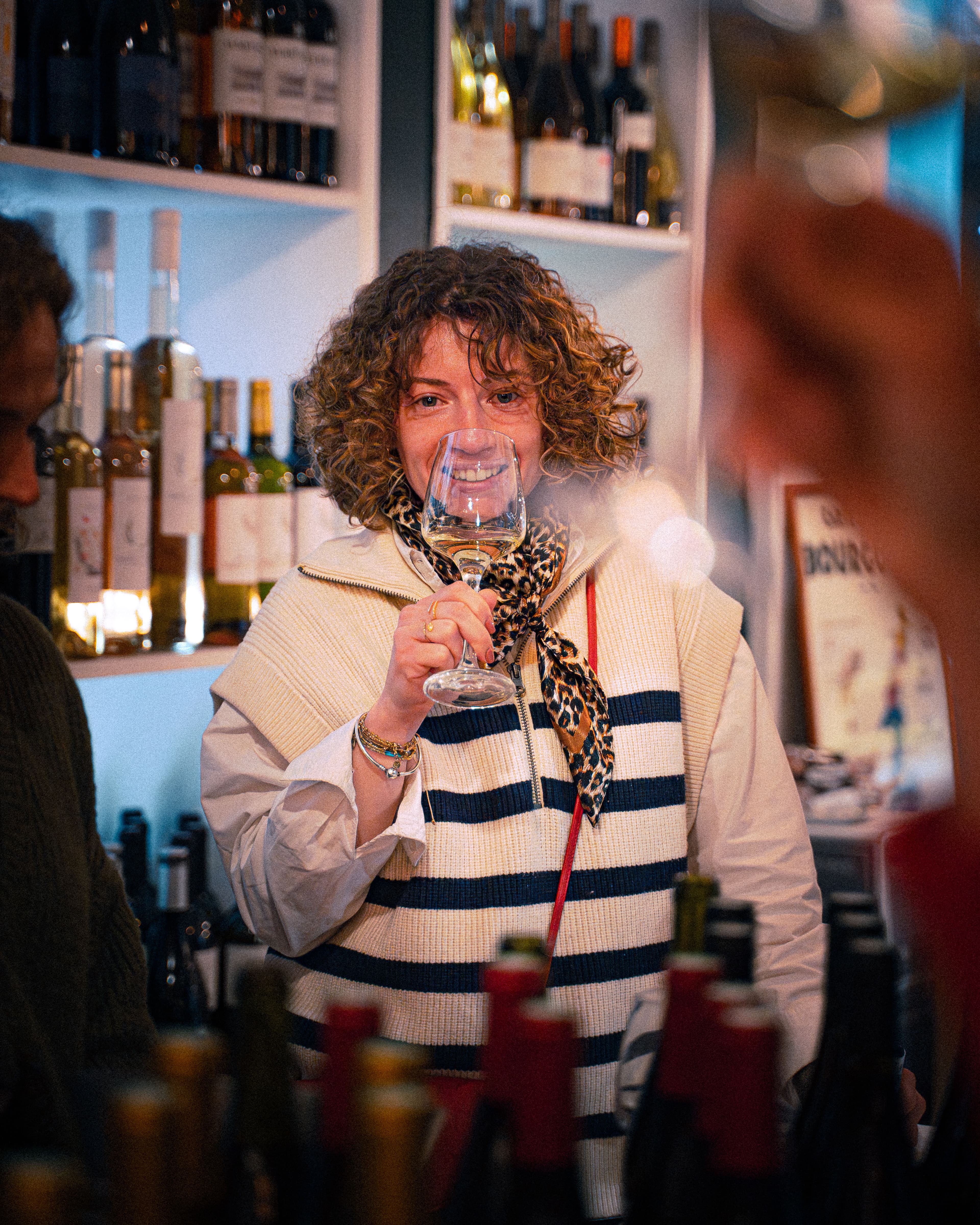 Une cliente sourit avec son verre, ambiance cave